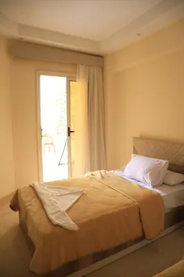 a bedroom with a large bed with a window at Kinga Apartment Florenza Khamsin in Hurghada