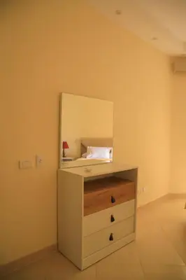 a bedroom with a dresser with a mirror on it at Kinga Apartment Florenza Khamsin in Hurghada