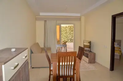 a kitchen and living room with a table and chairs at Kinga Apartment Florenza Khamsin in Hurghada