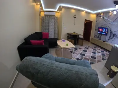 a living room with a couch and a tv at Hurghada Princess resort, Private Sandy Beach & 3 Pools in Hurghada