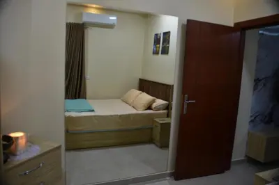 a small bedroom with a small bed and a mirror at Hurghada Princess resort, Private Sandy Beach & 3 Pools in Hurghada