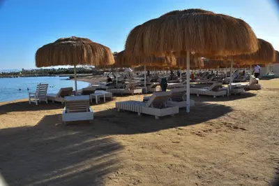 a bunch of chairs and umbrellas on a beach at Hurghada Princess resort, Private Sandy Beach & 3 Pools in Hurghada