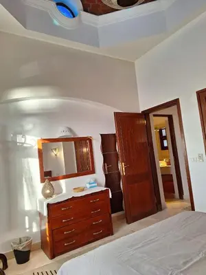 a bedroom with a bed and a dresser and a mirror at Bella Sabina, Lovely one bedroom chalet with pool in Hurghada