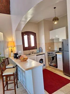 a kitchen with a counter top and a refrigerator at Bella Sabina, Lovely one bedroom chalet with pool in Hurghada
