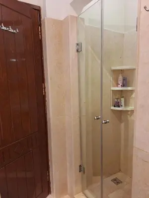 a shower with a glass door in a bathroom at Bella Sabina, Lovely one bedroom chalet with pool in Hurghada