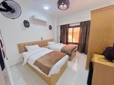 a bedroom with two beds and a window at JJ Guesthouse in Aswan