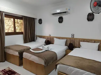 a room with three beds and a window at JJ Guesthouse in Aswan