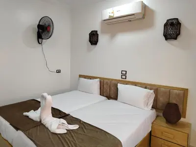 a bed with a stuffed animal sitting on a blanket at JJ Guesthouse in Aswan