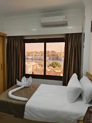 a hotel room with a bed with a large window at JJ Guesthouse in Aswan