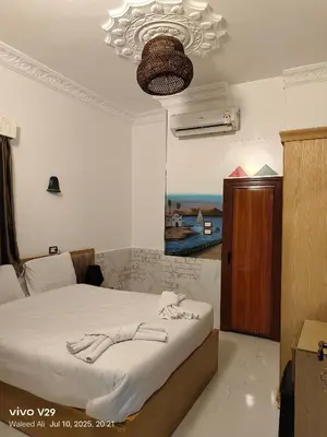 a bedroom with a bed and a chandelier at JJ Guesthouse in Aswan
