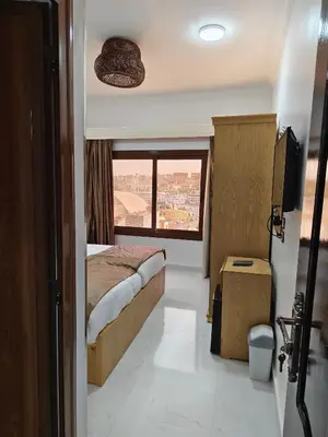 a bedroom with a bed and a large window at JJ Guesthouse in Aswan