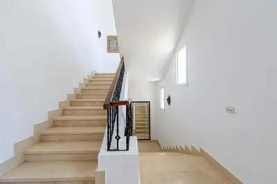 a staircase in a house with white walls and wooden floors at Stunning villa with private heatable pool in Hurghada