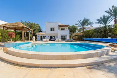 a large swimming pool in front of a house at Stunning villa with private heatable pool in Hurghada