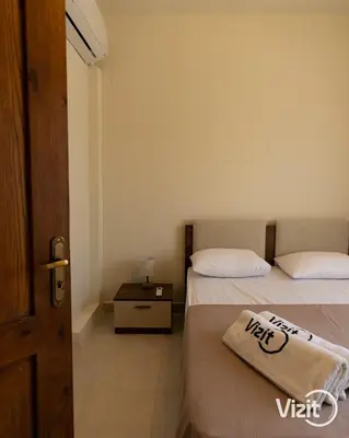 a bedroom with two beds and a door with a towel at Cosy flat in Makadi heights in Hurghada