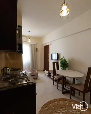 a kitchen and a living room with a table at Cosy flat in Makadi heights in Hurghada