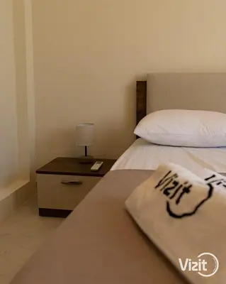 a bedroom with a bed and a table with a nightstand at Cosy flat in Makadi heights in Hurghada
