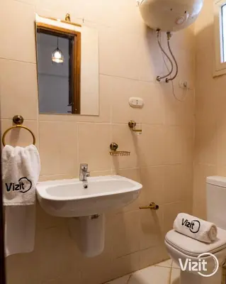 a bathroom with a sink and a toilet and a mirror at Cosy flat in Makadi heights in Hurghada