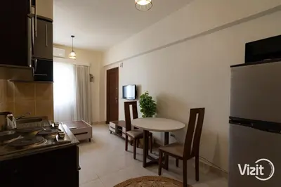 a kitchen and living room with a table and chairs at Cosy flat in Makadi heights in Hurghada