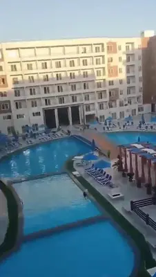 a large swimming pool in front of a large building at شالية بقرية الذهبية in Hurghada