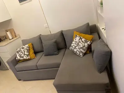 a gray couch with pillows in a living room at Modern Apartment with Direct Pool Access in Aqua Tropical in Hurghada