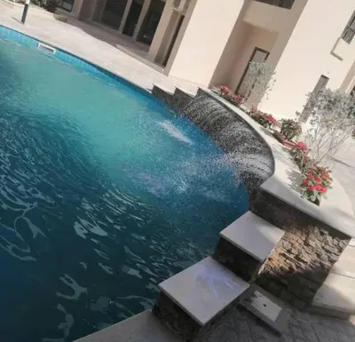a swimming pool with stairs next to a building at Modern Apartment with Direct Pool Access in Aqua Tropical in Hurghada