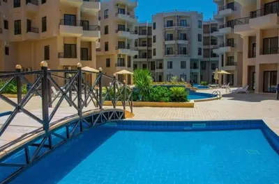 a swimming pool in front of some apartment buildings at Modern Apartment with Direct Pool Access in Aqua Tropical in Hurghada