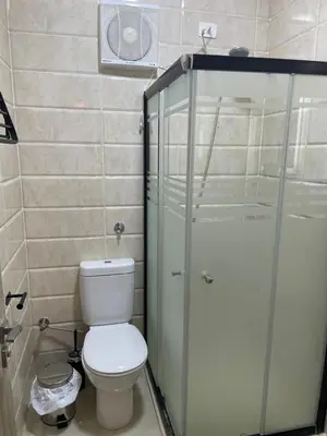 a bathroom with a toilet and a glass shower at Modern Apartment with Direct Pool Access in Aqua Tropical in Hurghada