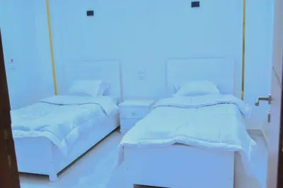 two beds in a hospital room with blue lighting at Jasmin house in ‘Ezbet Abu Ḥabashi