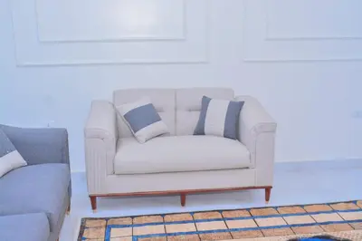 a white couch with two pillows on it in a living room at Jasmin house in ‘Ezbet Abu Ḥabashi