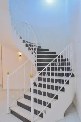 a staircase with a white railing and a stair case at Jasmin house in ‘Ezbet Abu Ḥabashi