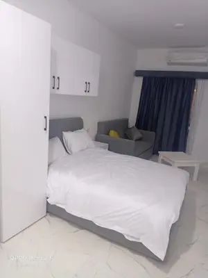a bedroom with a white bed and a couch at كمبوند لابرستيجا in Hurghada