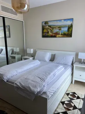 a bedroom with a white bed with a painting on the wall at SunShine Mangroovy-M10 in Hurghada