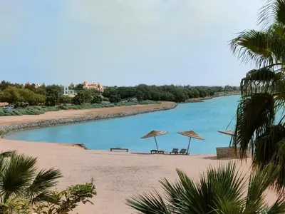 two chairs and umbrellas on a beach with a river at SunShine Y1-0-6 in Hurghada