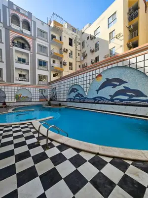 a swimming pool with a checkered floor and buildings at Sheraton Plaza 319 in Hurghada