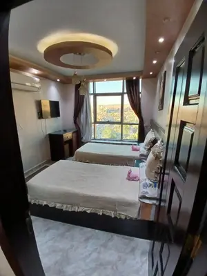 a hotel room with two beds and a window at Monty Homestay in Aswan
