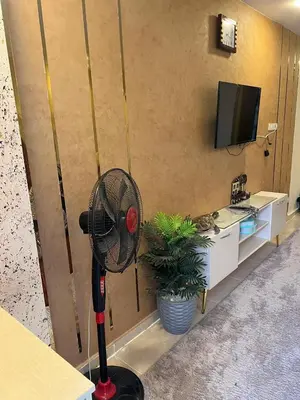 a room with a fan in a room with a tv at Tiba Golden Resort in Hurghada