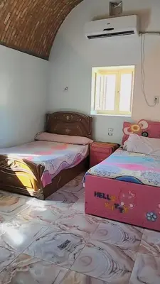 a bedroom with two beds and a box on the floor at Nuba in Aswan
