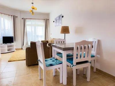 a kitchen and living room with a table and chairs at Stunning Nile view Apartment in Luxor