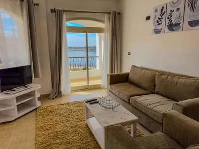 a living room with a couch and a tv at Stunning Nile view Apartment in Luxor