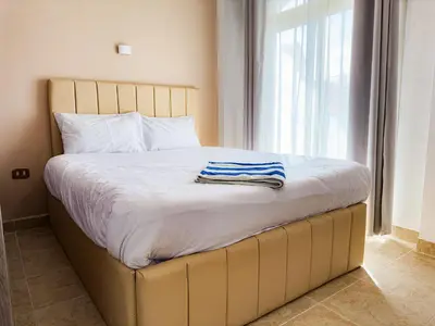 a bed with a wooden frame with a towel on it at Stunning Nile view Apartment in Luxor