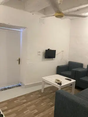 a living room with a couch and a table and a tv at Habu House Luxor in Luxor