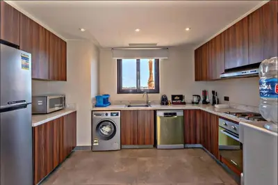 a kitchen with wooden cabinets and a washer and dryer at Luxury villa in gouna in Hurghada