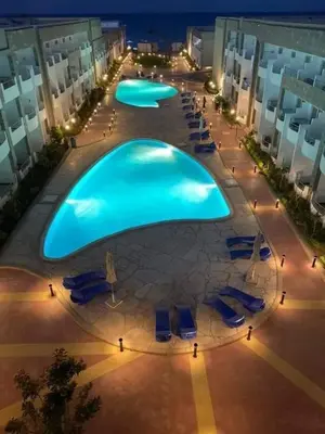 an overhead view of a large swimming pool at night at Furnished Chalets for Rent in Cecilia Resort Furnteched, kitchenee, Near Airport in Hurghada