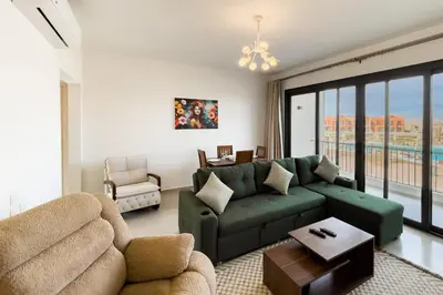 a living room with a green couch and a table at Prim & Pleasing 1BDR Kamaran El Gouna in Hurghada
