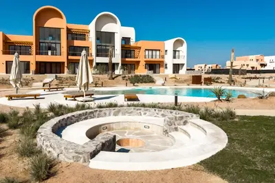 a resort with a swimming pool and a building at Prim & Pleasing 1BDR Kamaran El Gouna in Hurghada