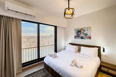 a bedroom with a bed and a large window at Prim & Pleasing 1BDR Kamaran El Gouna in Hurghada