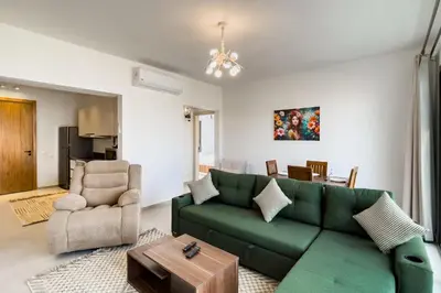 a living room with a green couch and a table at Prim & Pleasing 1BDR Kamaran El Gouna in Hurghada
