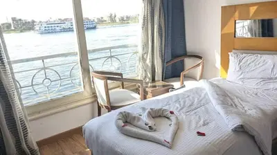 a hotel room with a bed with a view of the water at 4 Days Nile Cruise from Luxor to Aswan in Luxor