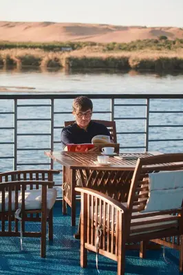 a man sitting at a table on a cruise ship at 4 Days Nile Cruise from Luxor to Aswan in Luxor