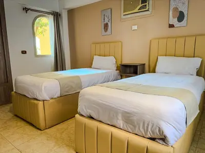 two beds sitting next to each other in a room at Nile view Apartment in Luxor